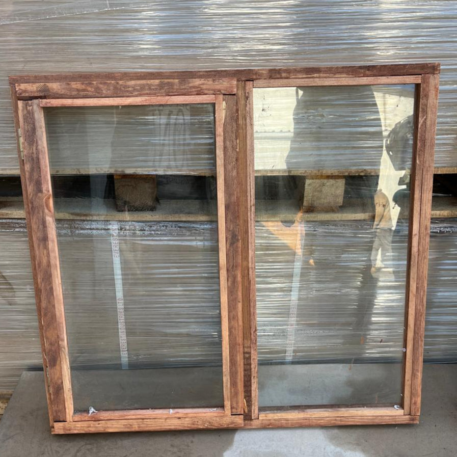 Wooden window frame with glass panes against a corrugated metal background